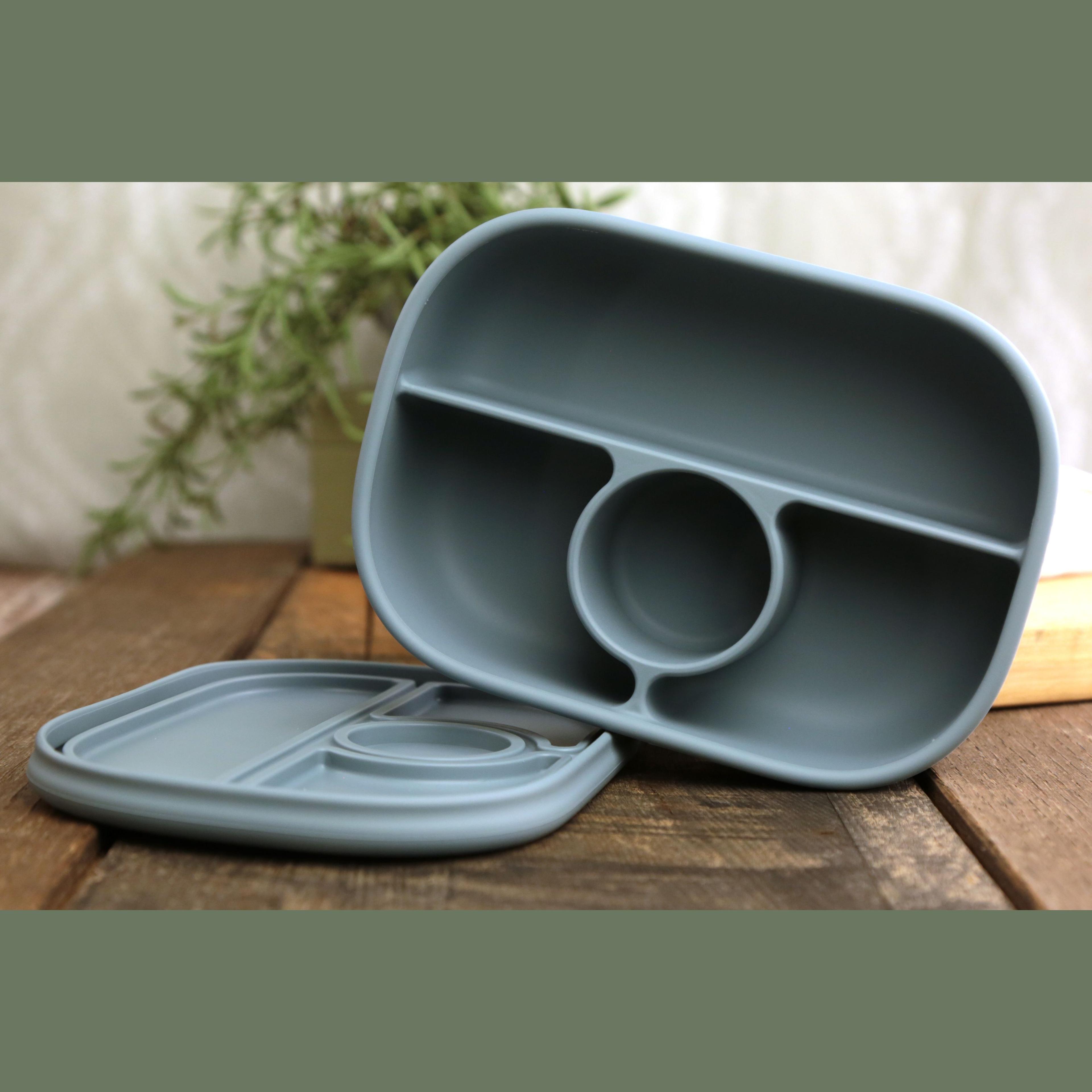 Calla and Friends silicone bento box in dusty blue color showing empty compartments with lid removed on wooden surface