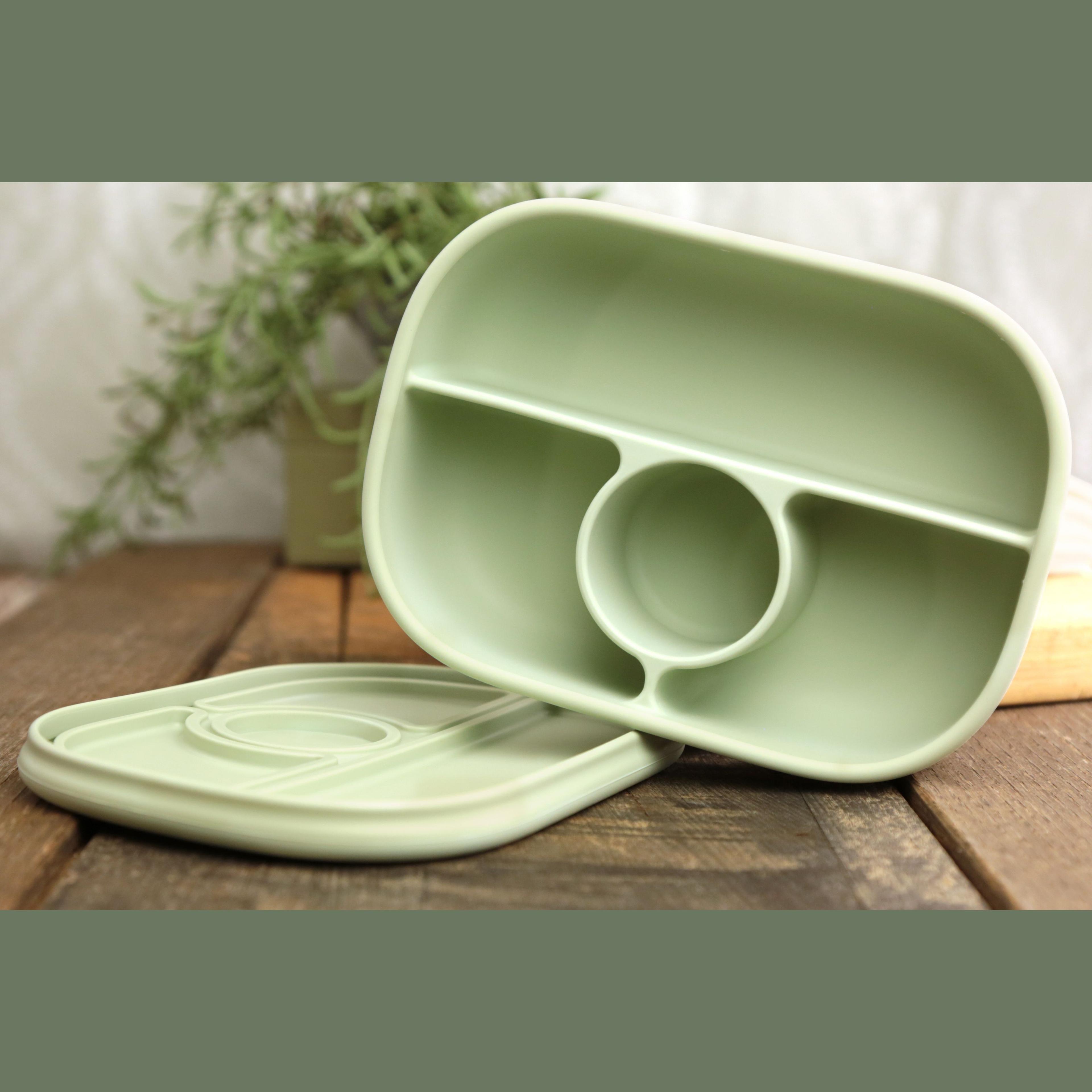 Calla and Friends silicone bento box in sage green color showing empty compartments with lid removed on wooden surface