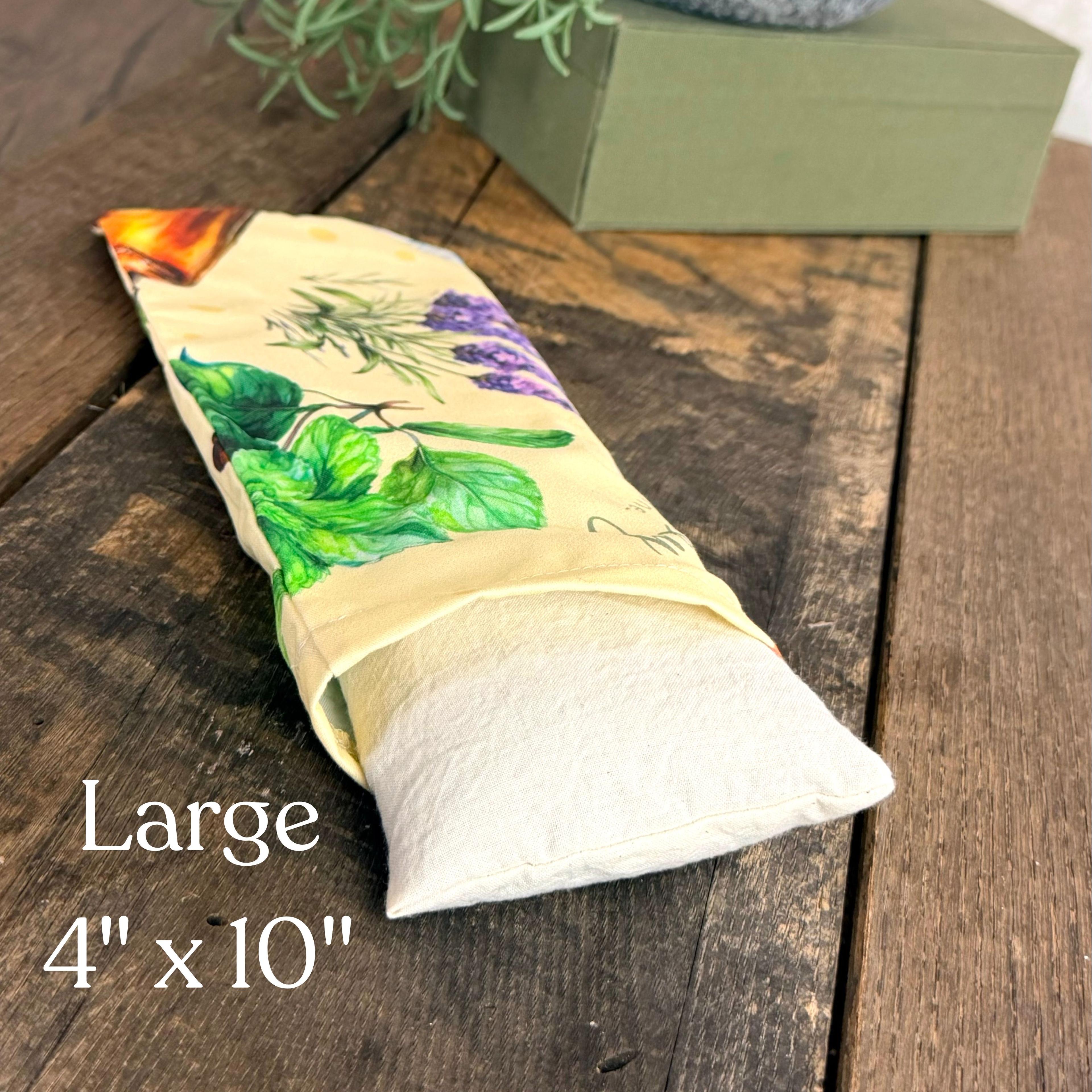 Large herbal eye pillow with botanical print featuring lavender, mint leaves, and other healing herbs on natural fabric