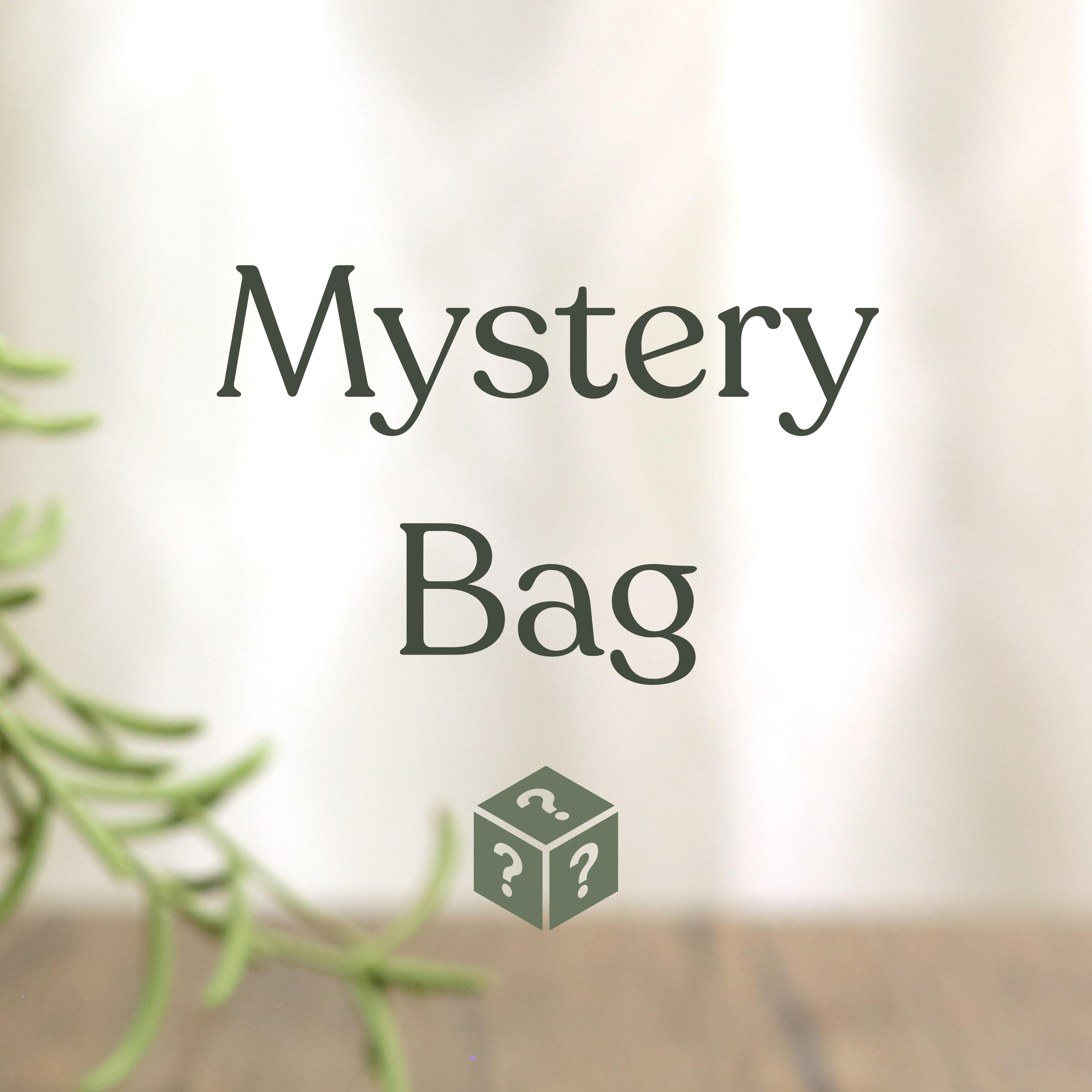 Mystery Bag text with green cube icon featuring question marks, blurred plant in background