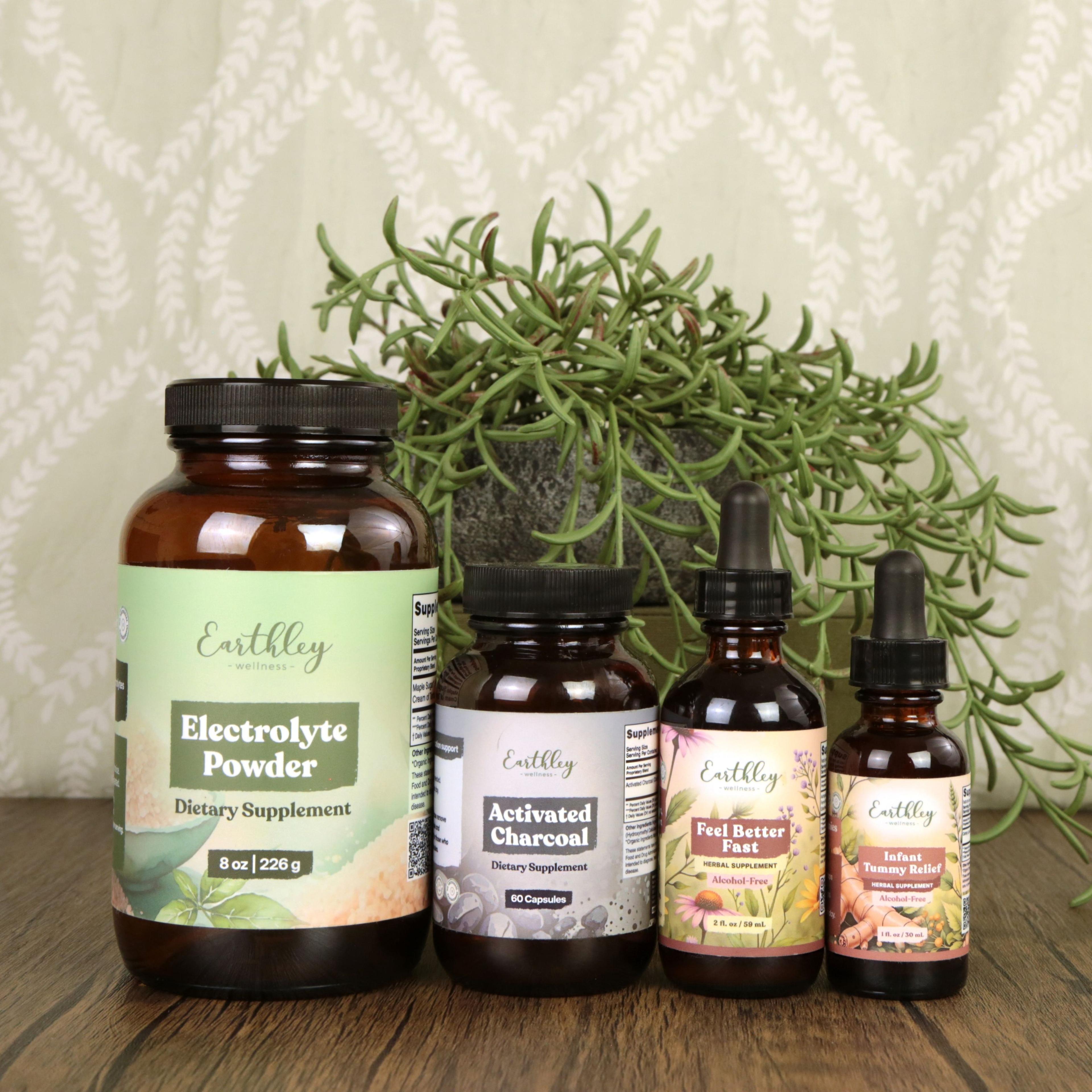 Four Earthley wellness products arranged on wood surface: Electrolyte Powder, Activated Charcoal capsules, Feel Better Fast tincture, and Infant Tu...