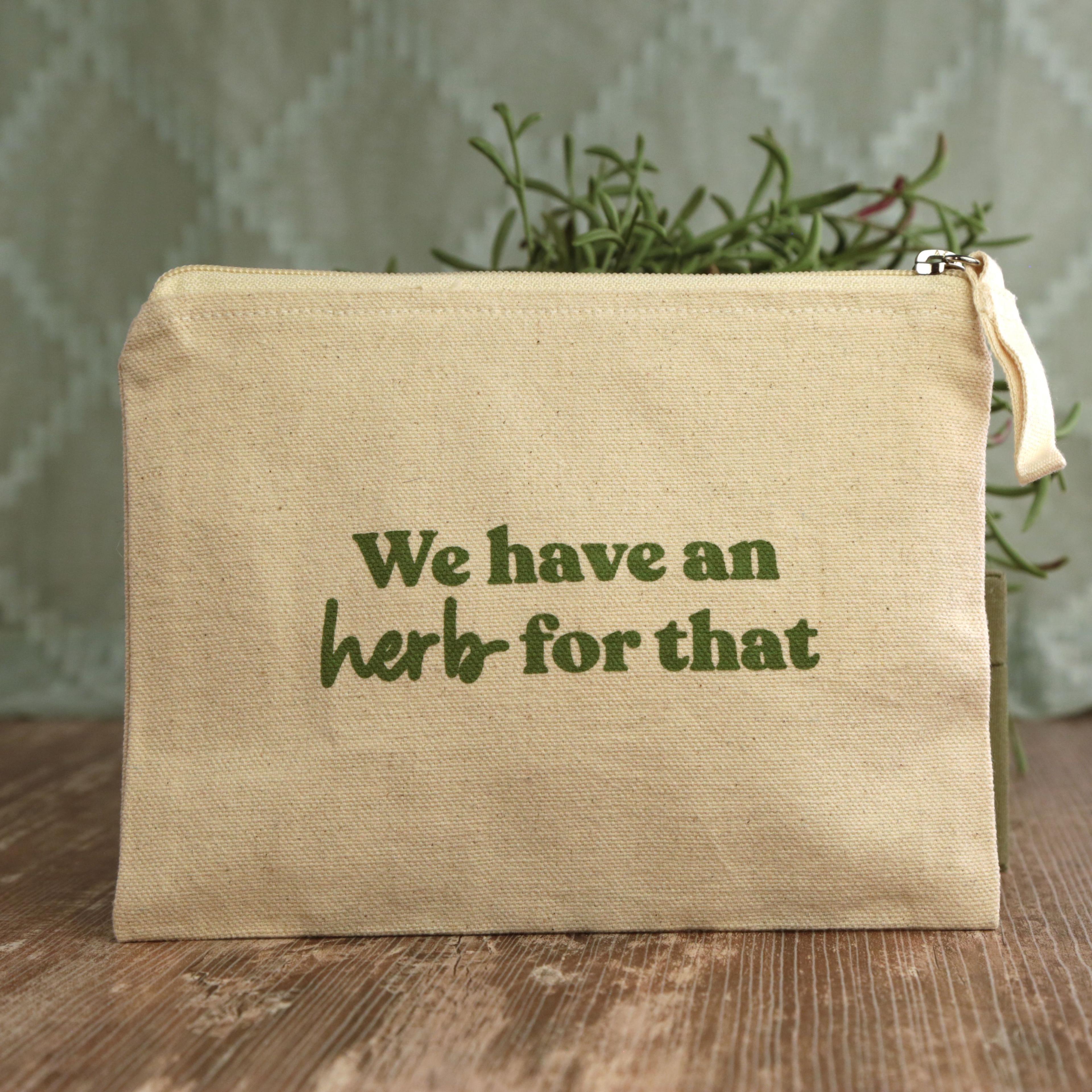 Earthley Tincture Carrying Bag front view natural canvas pouch with green text We have an herb for that and gold zipper on rustic wood with rosemary
