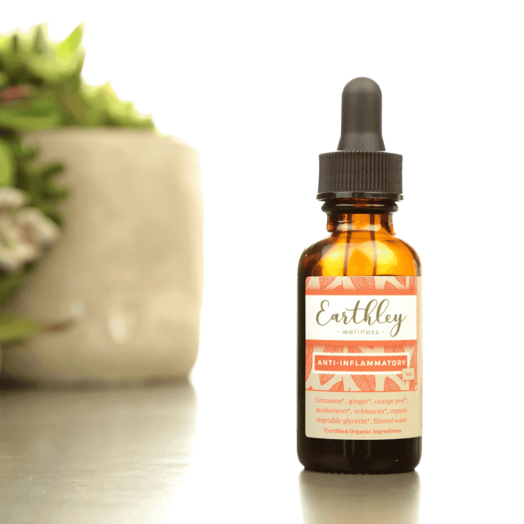 Earthley Anti-Inflammatory tincture bottle with orange pattern label and blurred plant background