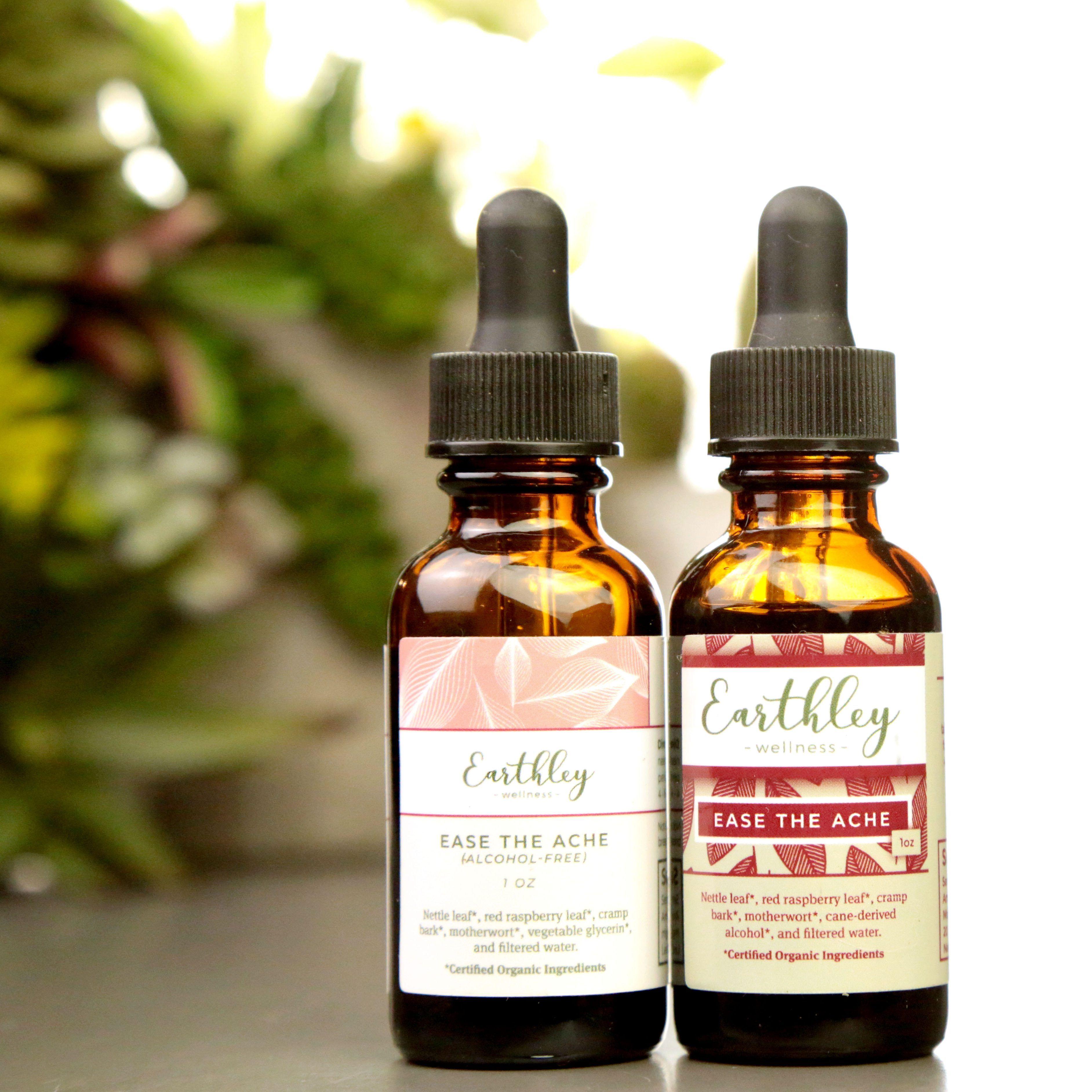 Two Earthley Ease the Ache tincture bottles in 1oz sizes showing alcohol-free and regular versions with pink leaf label design and plants in background