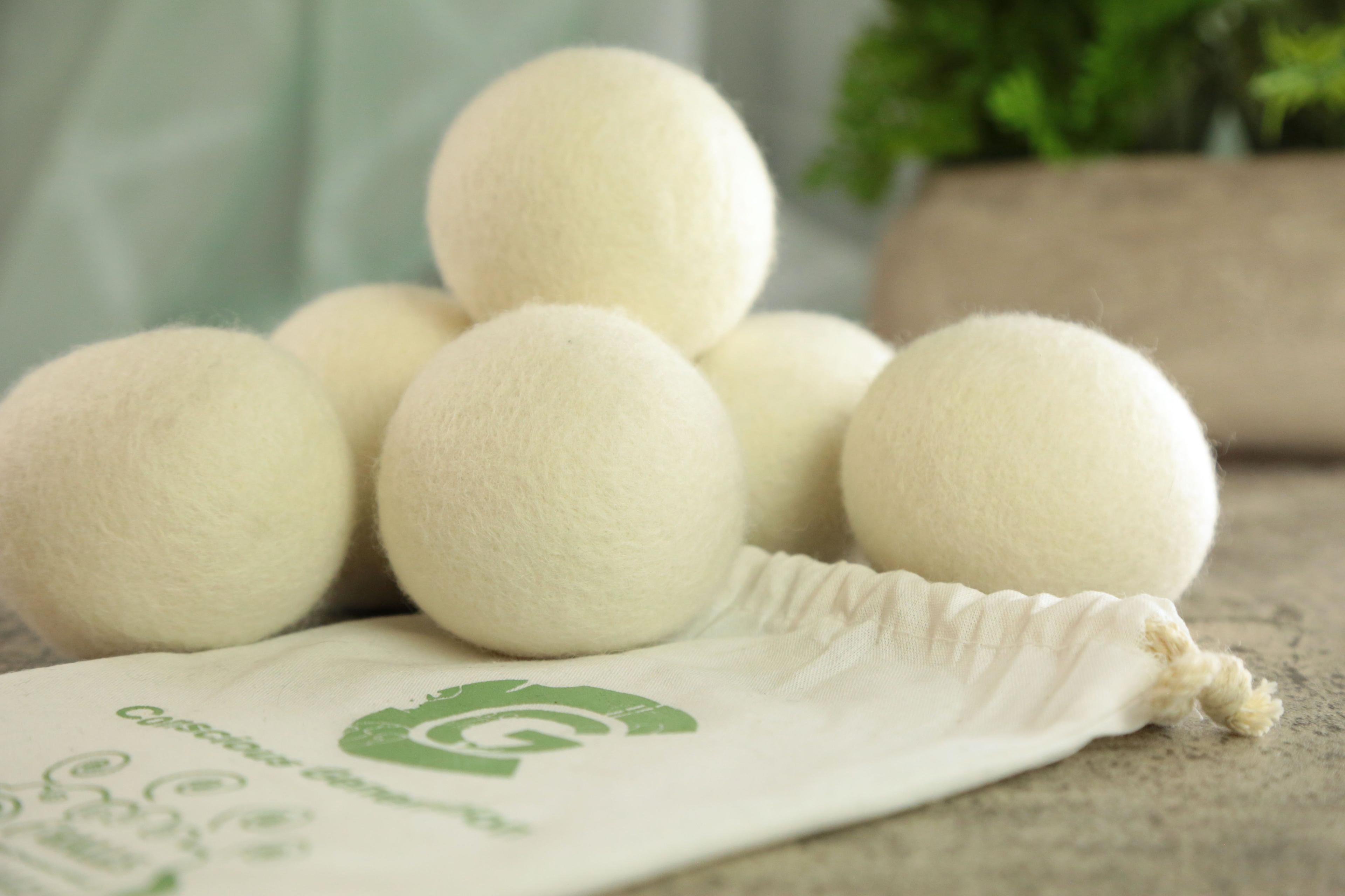 Earthley Wool Dryer Balls in hand demonstrating size approximately tennis ball sized natural white felted wool