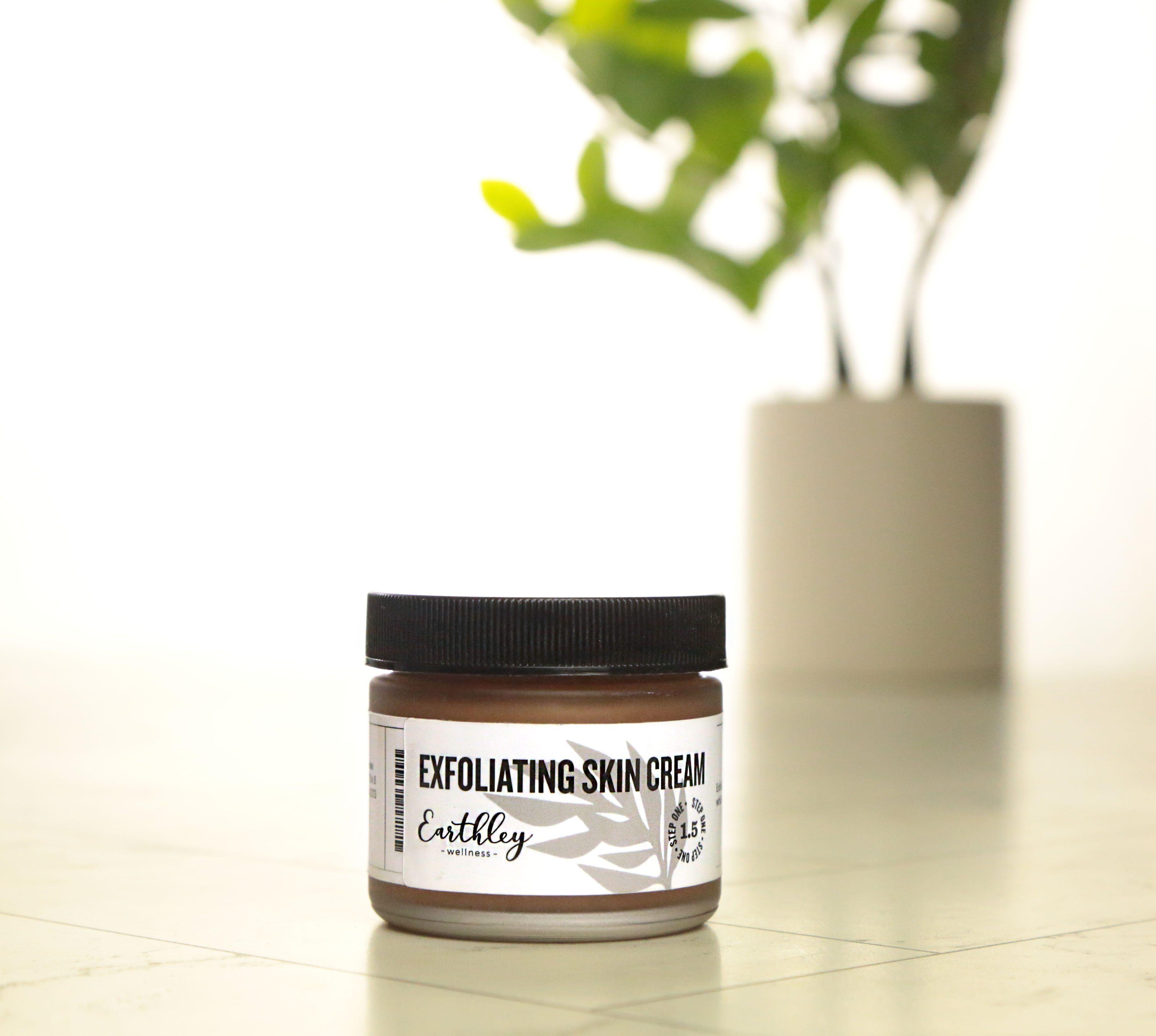 Exfoliating Skin Cream Step 1.5 in amber jar with gray leaf label and green plant in background