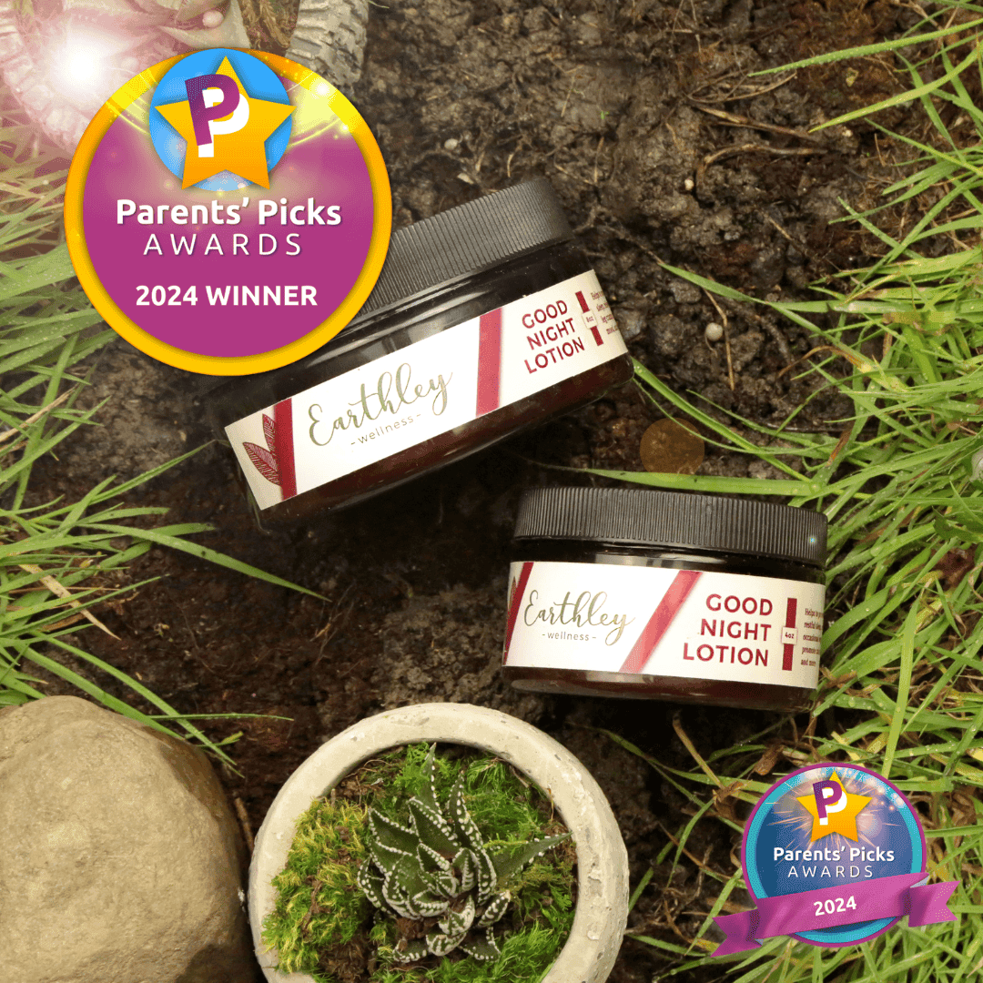 Two Earthley Good Night Lotion jars in grass with Parents' Picks Awards 2024 Winner badges and succulent plant