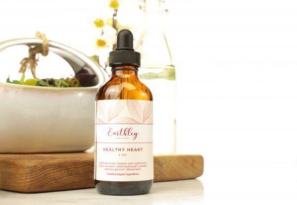Healthy Heart herbal extract shown in amber dropper bottle on wooden cutting board