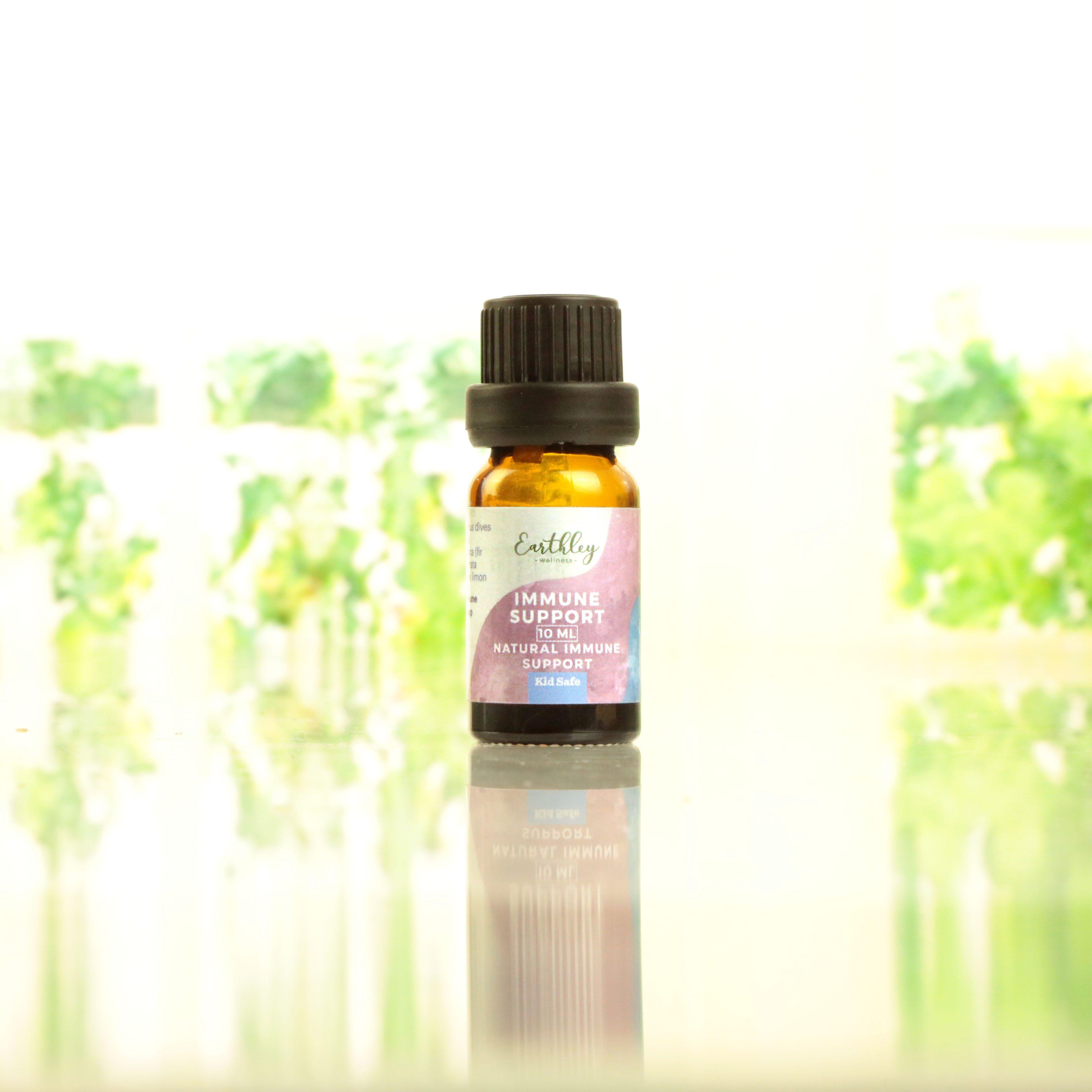 Immune Support essential oil blend 10ml Kid Safe amber bottle with pink and blue watercolor label reading Natural Immune Support on reflective surface