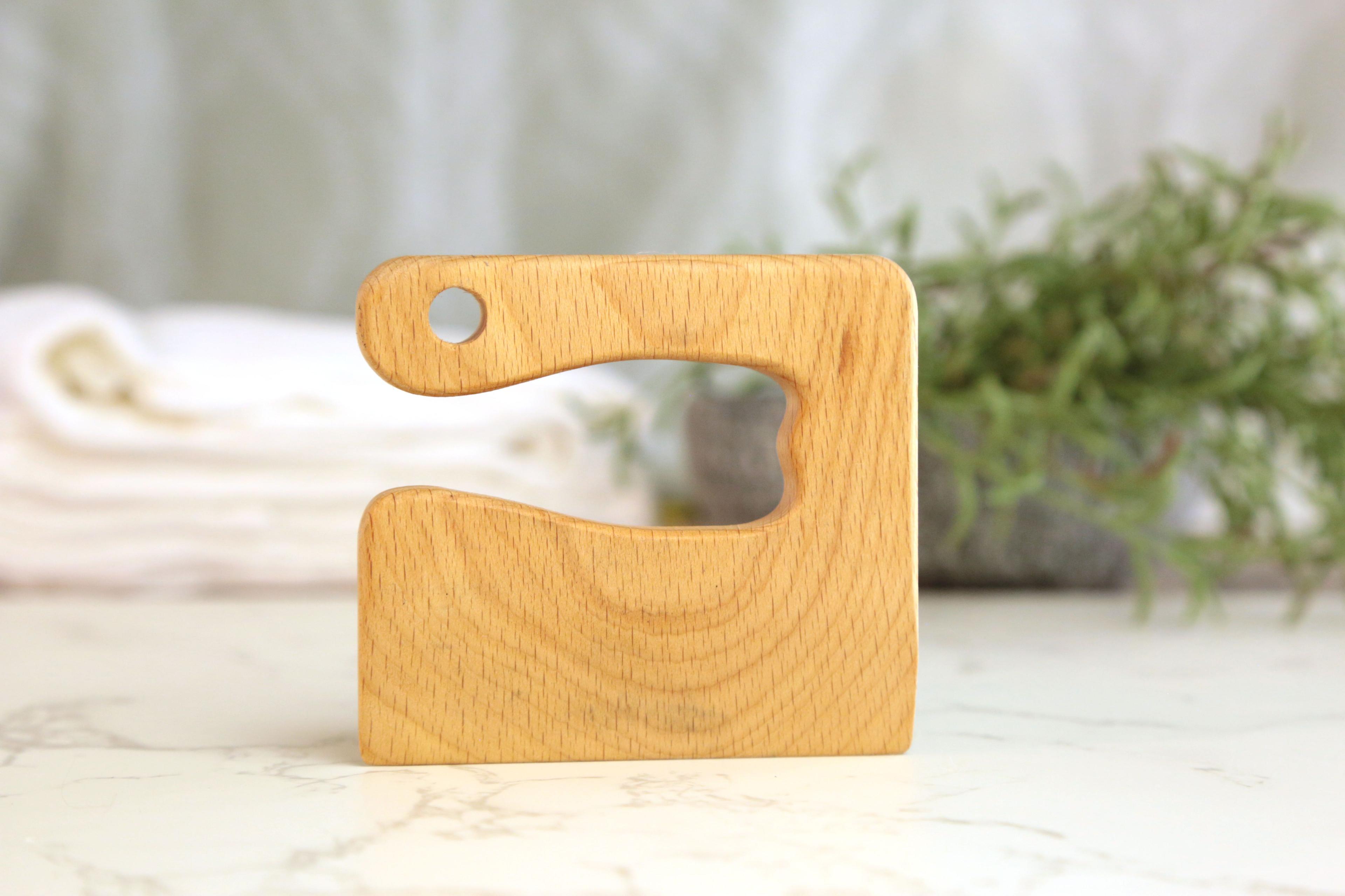 Earthley kids safety knife with wooden handle and wavy blade edge demonstrating safe cutting tool for children on marble surface