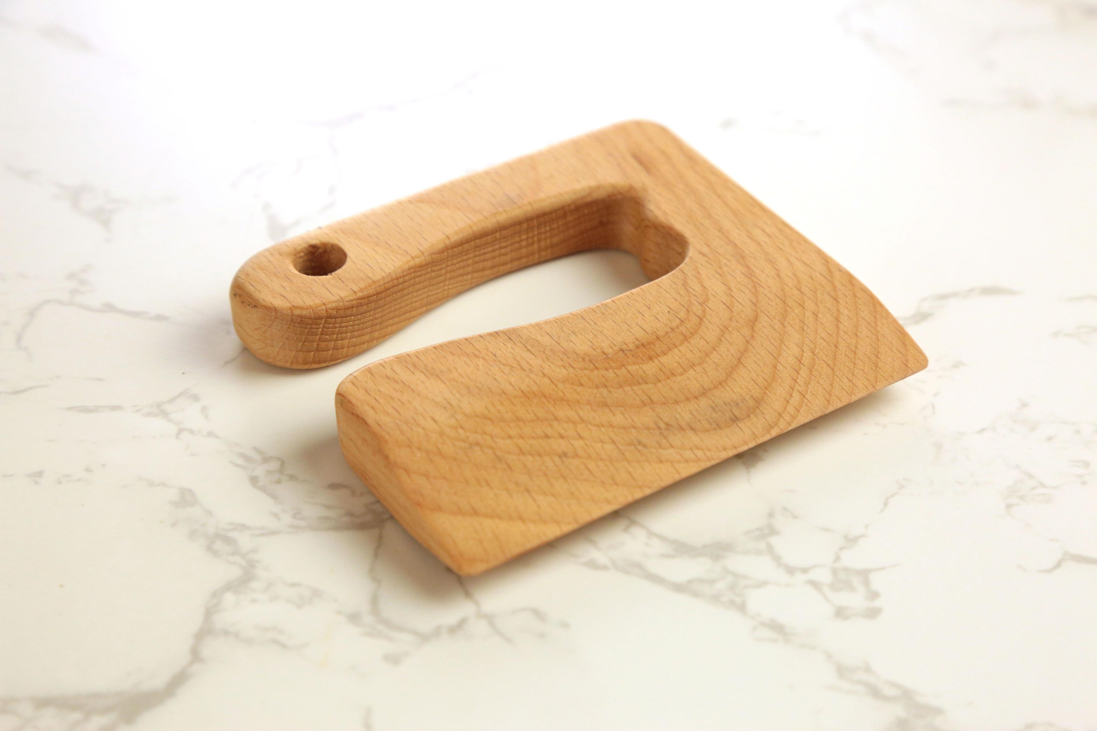 Earthley kids safety knife with rounded blade and wooden handle designed for young children learning to cook on marble surface