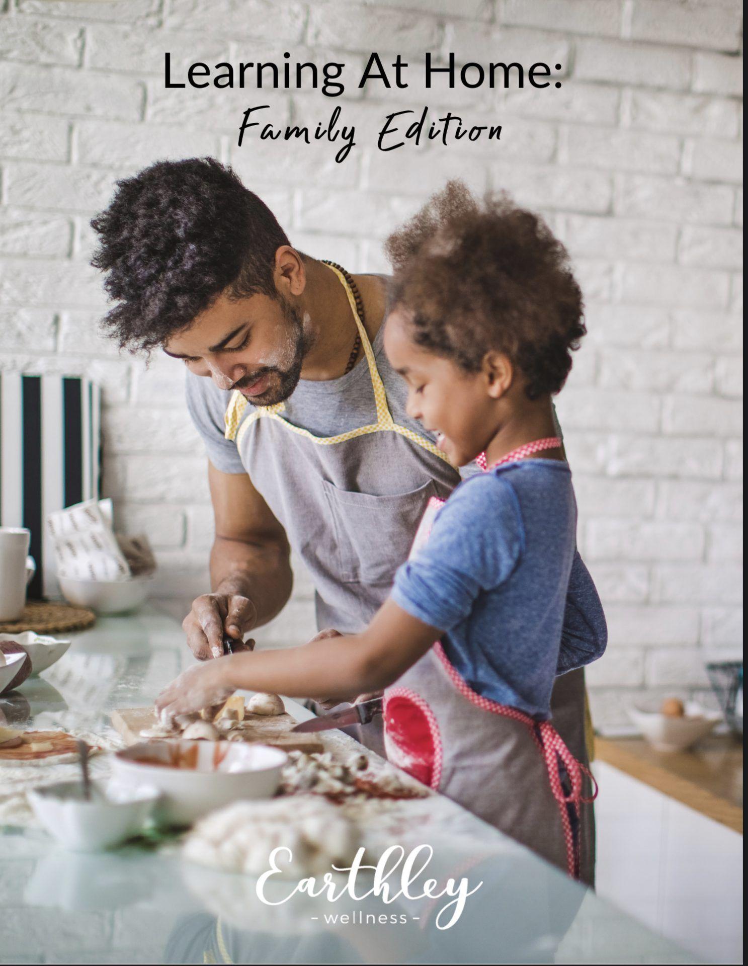 Earthley Learning At Home Family Edition guide cover showing father and child with dark curly hair cooking together in gray and red aprons in white brick kitchen