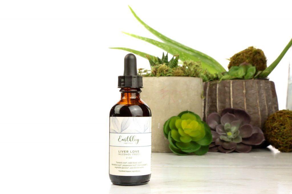 Liver Love herbal extract in amber dropper bottle with green label surrounded by succulents
