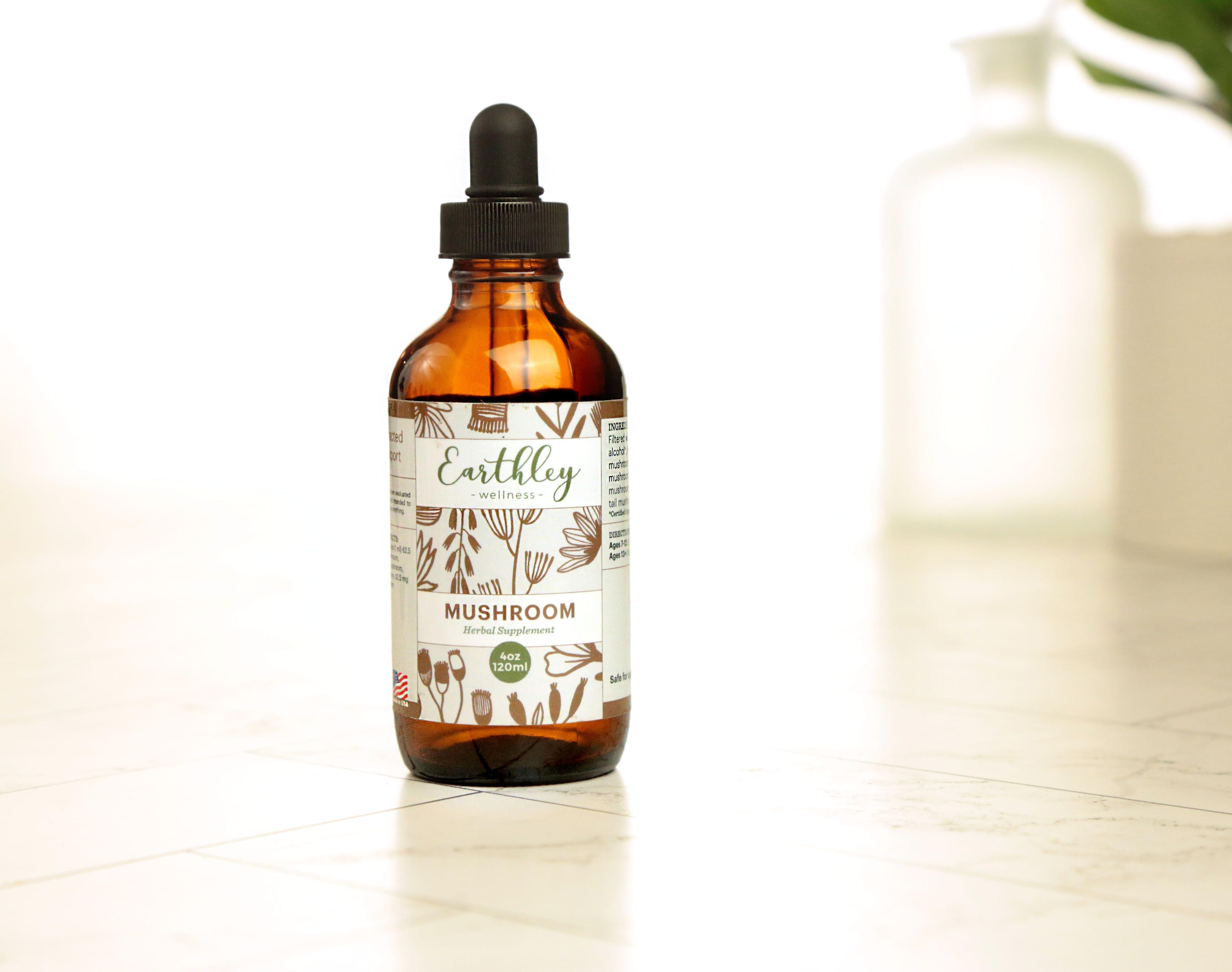 Earthley Mushroom 4oz amber dropper bottle with brown botanical label design on marble surface