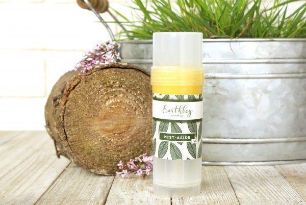 Pest Aside bug repellent stick with wood slice and lavender flowers in rustic setting
