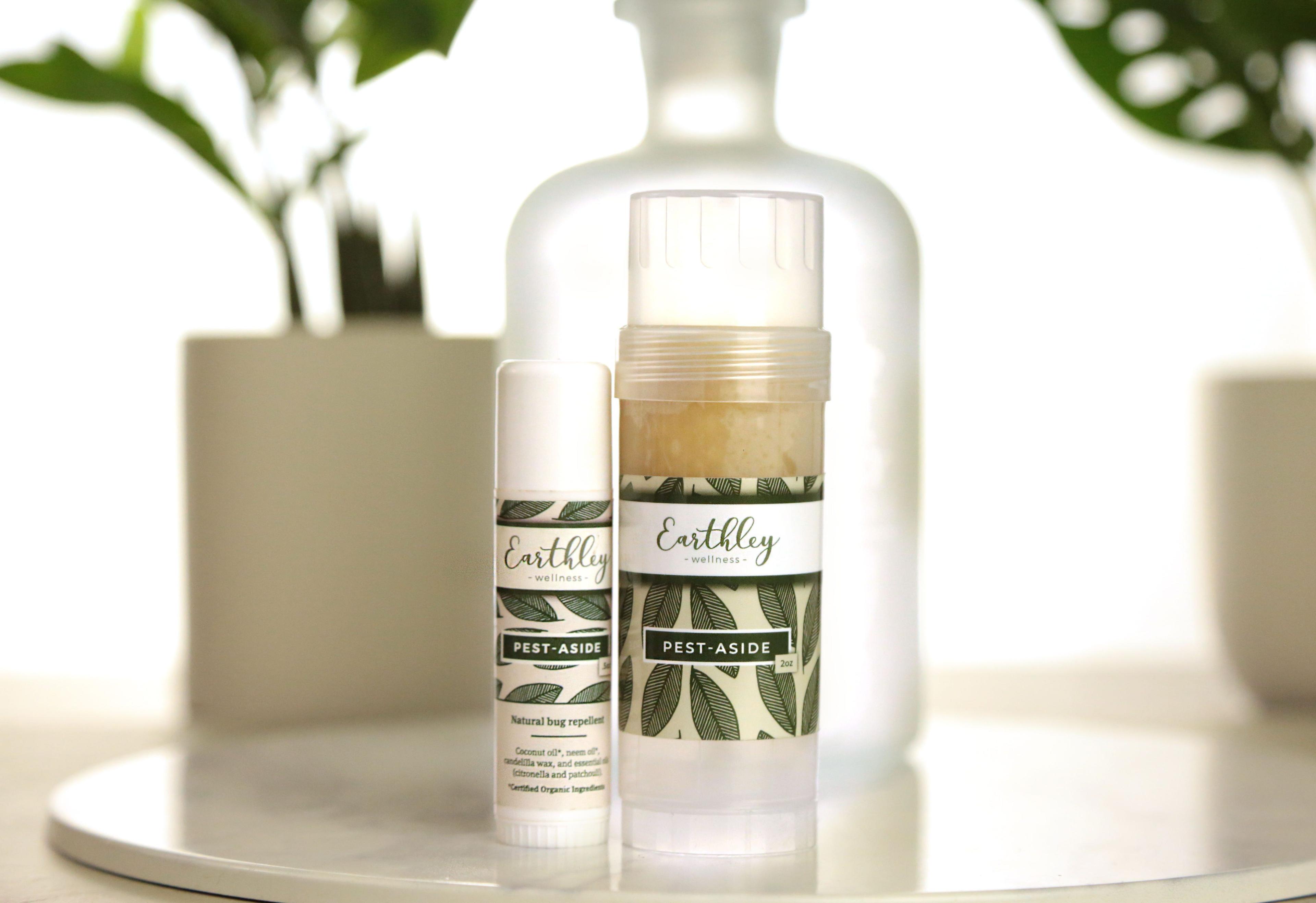 Two Pest Aside natural bug repellent sticks in travel and full sizes with green leaf pattern labels