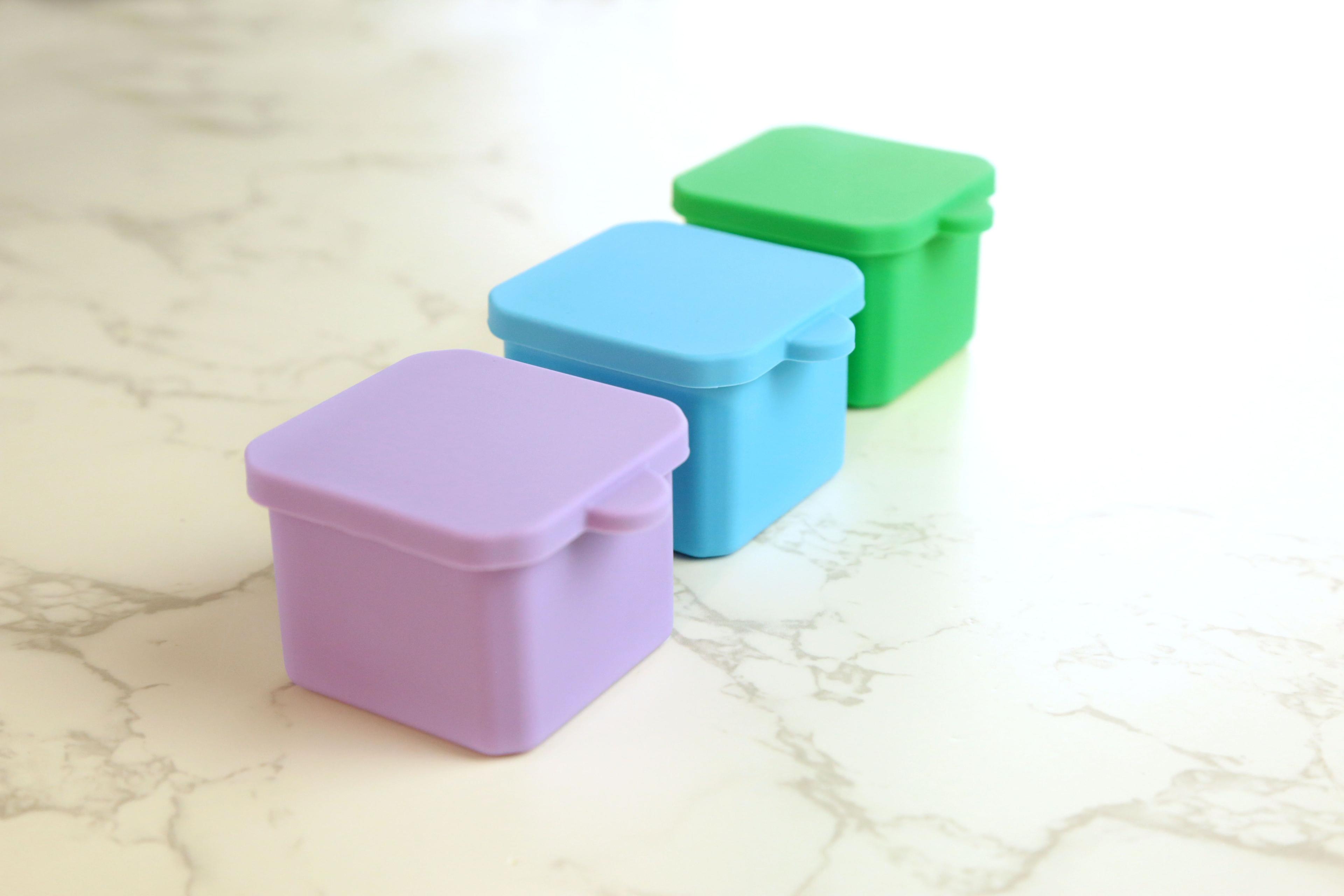 Earthley stainless steel sauce cup 2oz portion container with lid showing small food storage size on marble surface