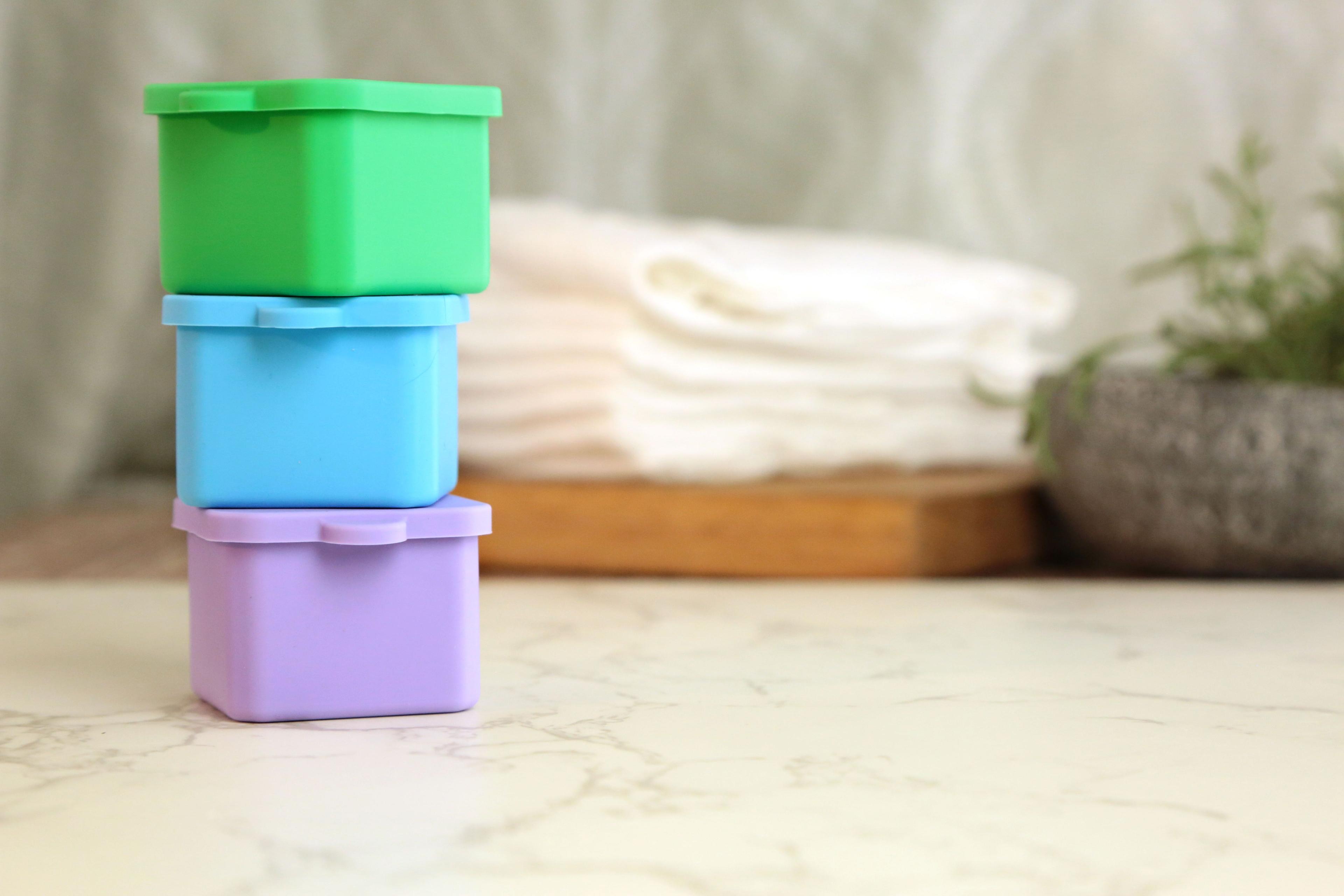 Earthley stainless steel sauce cups stacked showing nestable space-saving design with snap-on lids on marble surface