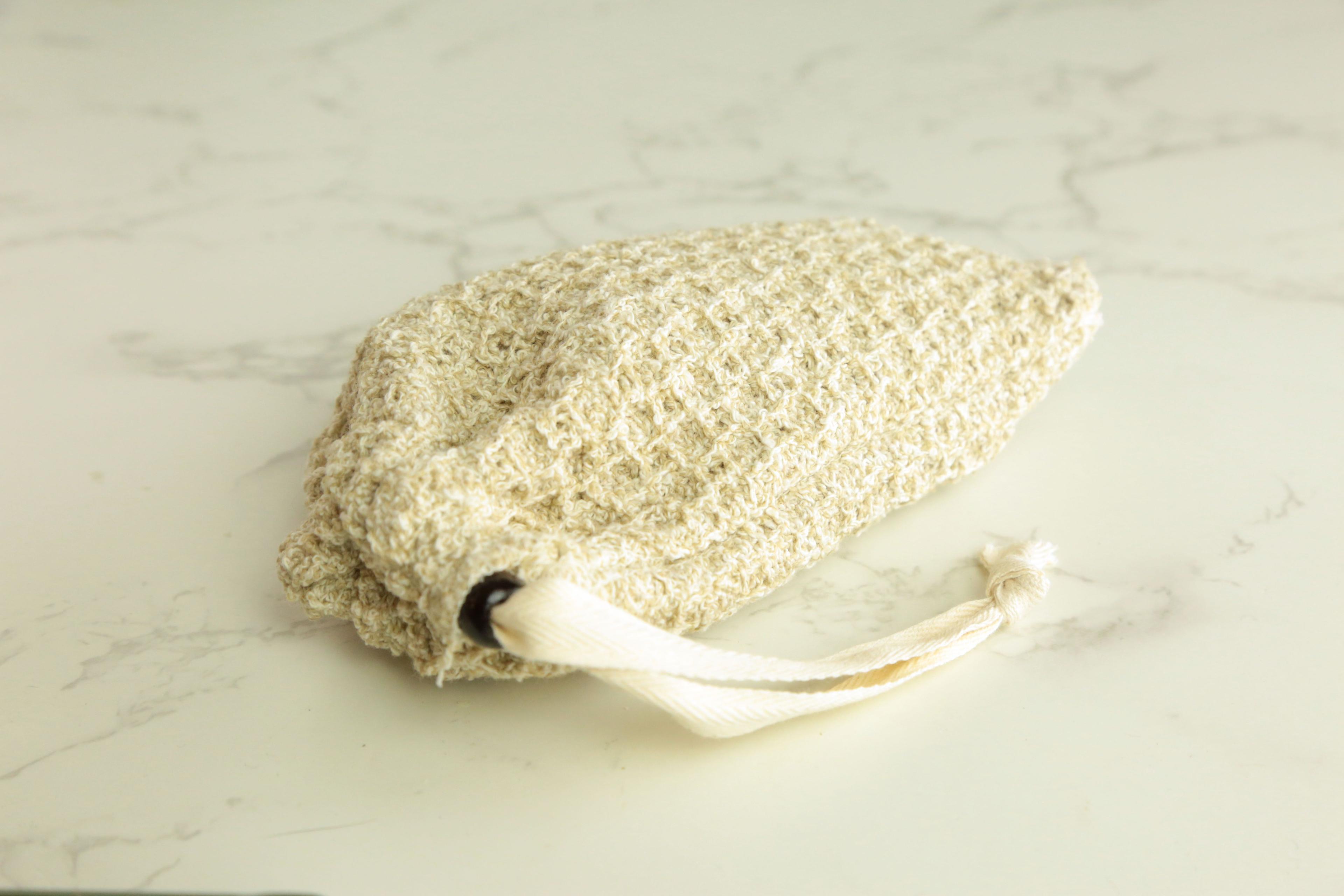 Earthley natural sisal soap pouch exfoliating bag in cream color with drawstring for lathering bar soap on marble surface
