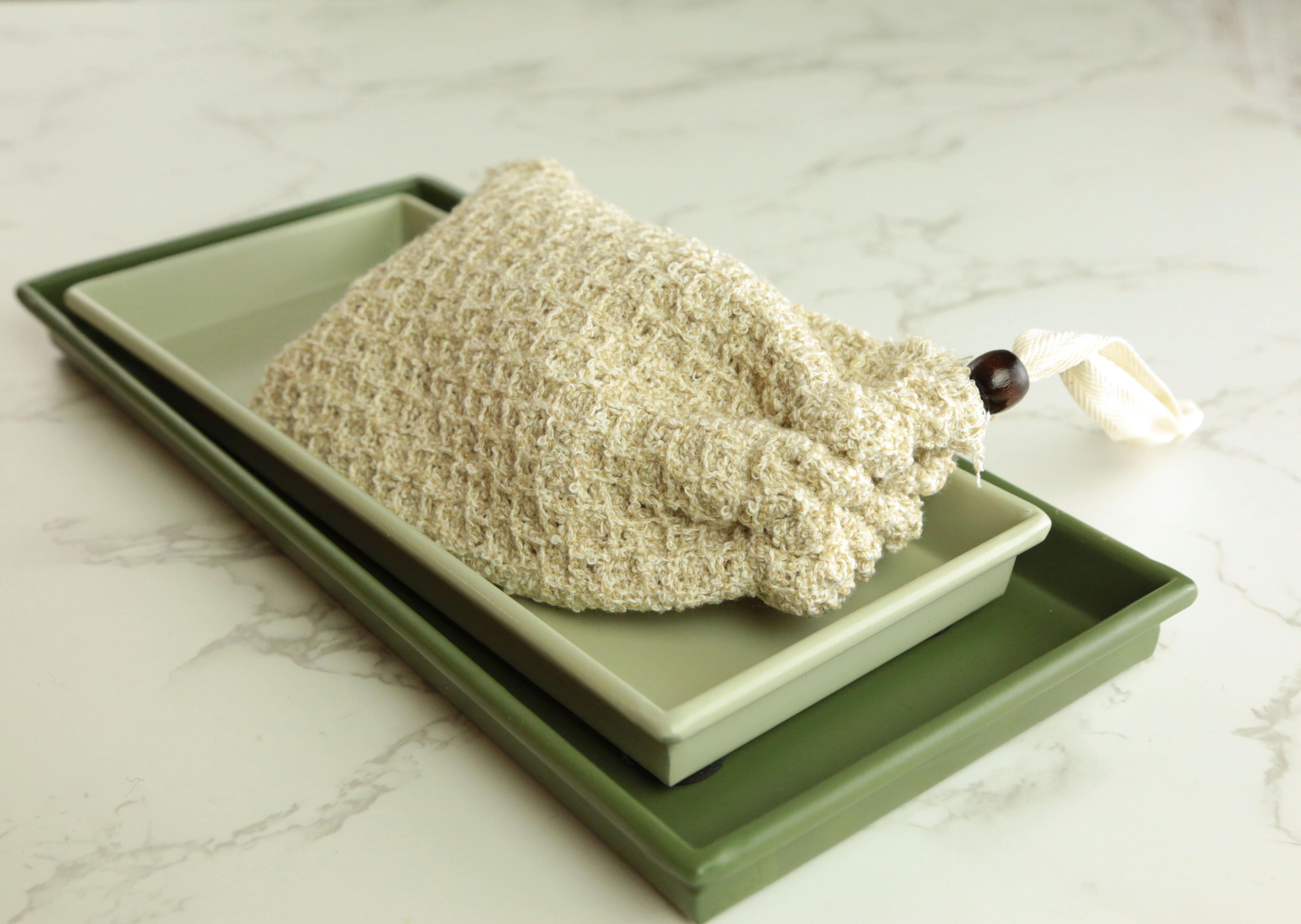 Earthley natural sisal soap pouch with bar soap visible through mesh showing exfoliating texture on marble surface with eucalyptus