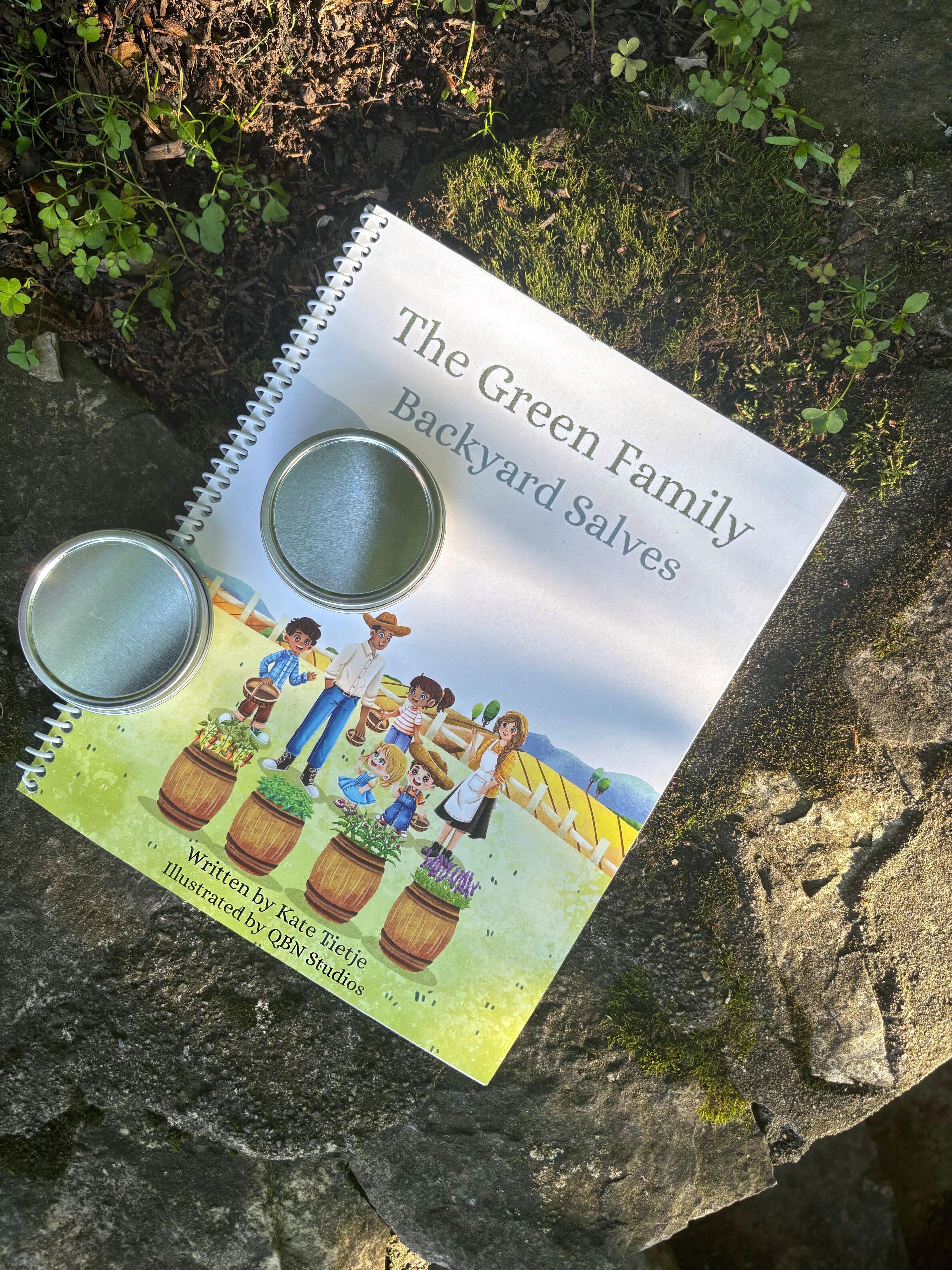 The Green Family Backyard Salves childrens book cover with two small tin containers on top showing illustrated family with herb barrels on mossy stone