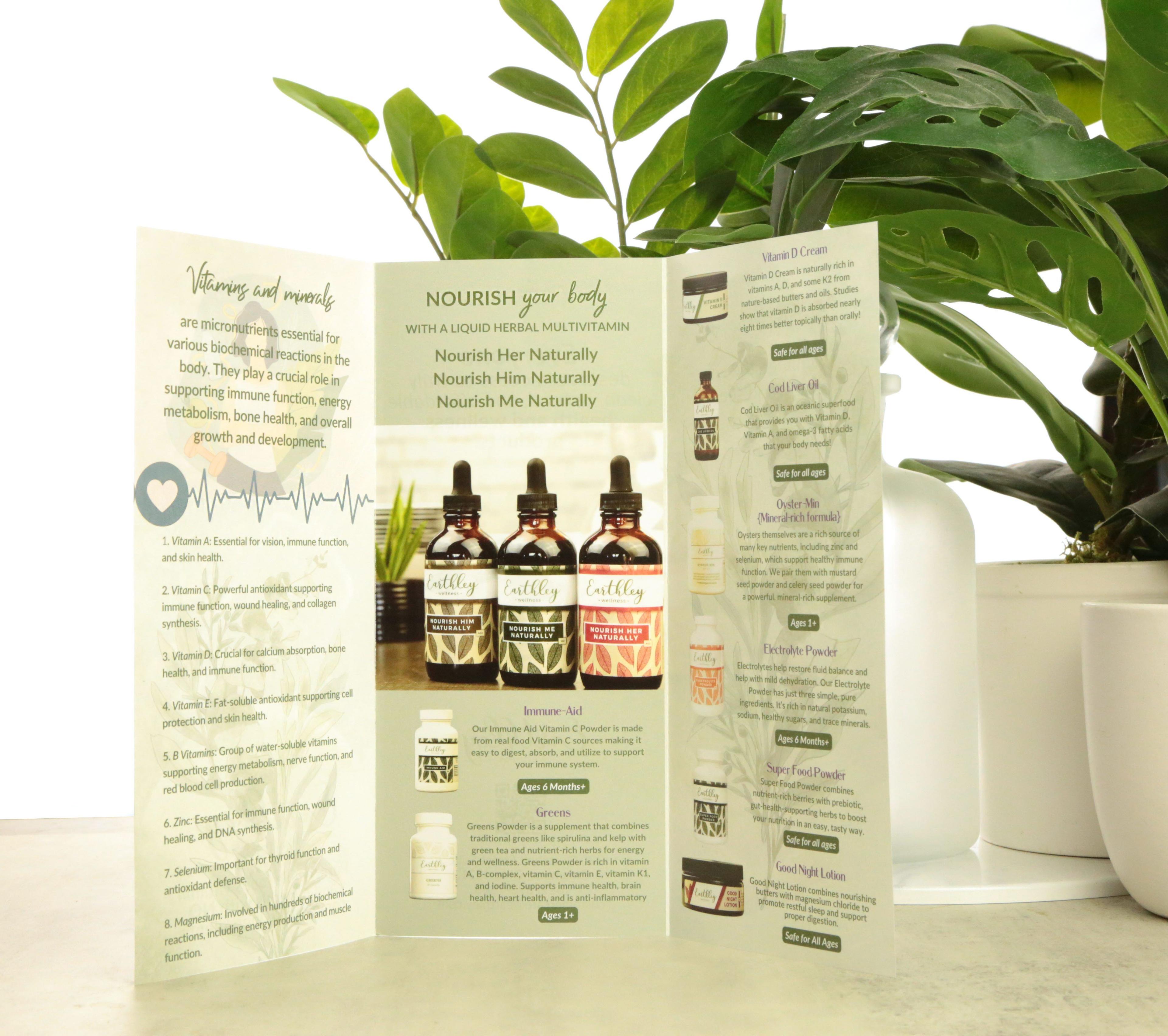 Earthley Vitamins and Minerals wholesale brochure trifold standing open showing amber glass Nourish tincture bottles green leaf design white panels with product descriptions and green monstera leaves in background